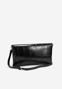 Bolso negro con relieve de cocodrilo, con forma rectangular plana, acabado liso y brillante, asa de hombro desmontable y cierre de cremallera.