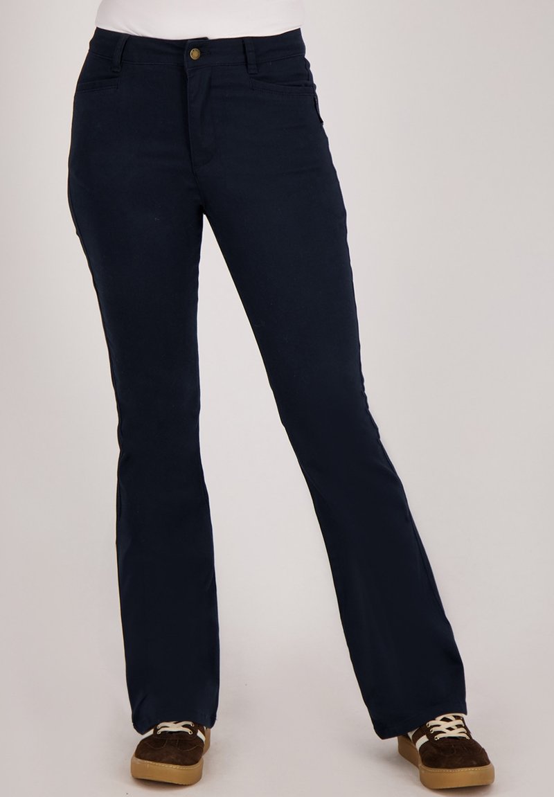 Marineblauwe wijde broek van gladde stof, met zakken aan de voorkant en een knoopsluiting in de taille. Draagt bruine veterhoesjes.