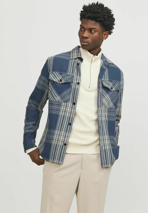 Geruite shirt in blauw en grijs, gemaakt van geweven stof. Heeft twee borstzakken, knoopsluiting en een gestructureerde kraag. Casual pasvorm.