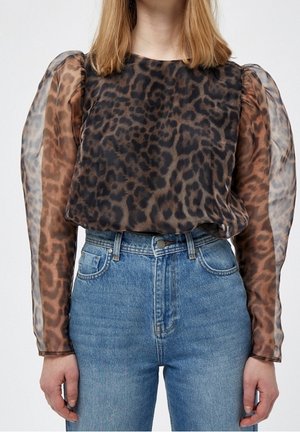 Top de leopardo con mangas abullonadas de chiffon marrón y escote redondeado, combinado con jeans de tiro alto azul claro.