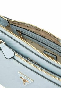 Borsa a tracolla in ecopelle testurizzata di colore azzurro chiaro con zip e accessori dorati. Presenta un interno con marchio e numerosi scomparti per l'organizzazione.