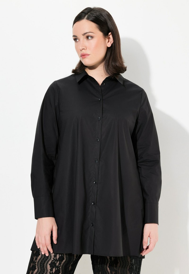Camicia nera con bottoni, maniche lunghe, colletto e vestibilità ampia. Realizzata in tessuto morbido, presenta un orlo dritto e un leggero lucido.