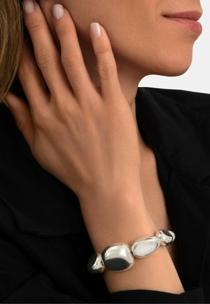 Bracelet en argent avec des perles lisses et arrondies de tailles variées, avec une finition polie et un mélange de textures mates et brillantes.