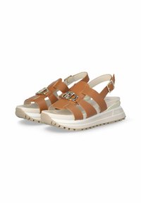 Brown leather sandals with multiple wide straps, a decorative metal buckle, and a thick white and beige sole with textured tread.