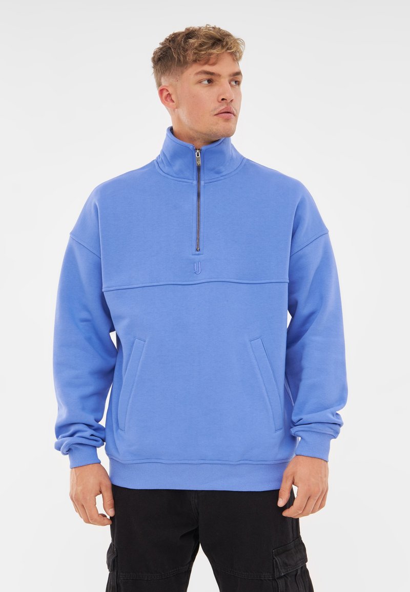 Lichtblauwe, rits-sweatshirt met een hoge kraag, verlaagde schouders, twee voorkliks en ribgebreide manchetten en zoom. Zachte textuur.