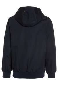 Giacca a vento blu navy con cappuccio, con polsini e cintura elasticizzati, caratterizzata da un piccolo dettaglio del logo e una trama di tessuto liscia. Vista posteriore mostrata.