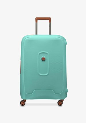 Maleta dura en color teal con un acabado texturizado, mango telescópico marrón y cuatro ruedas para mayor movilidad. Cuenta con un candado circular.