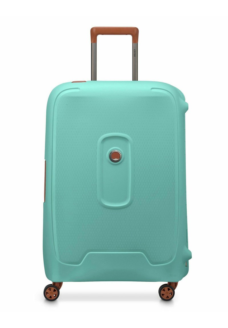 Valigia rigida di colore teal con finitura texture, manico telescopico marrone e quattro ruote per la mobilità. Dotata di una serratura circolare.