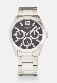 Orologio in acciaio inox argentato con un quadrante nero texturizzato, marcatori delle ore audaci, tre sottodial e un bracciale in metallo lucido.