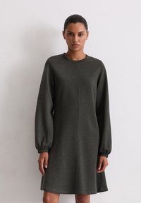 Robe-sweat à manches longues et ballons, de couleur vert foncé et à encolure arrondie. Confectionnée dans un tissu doux et texturé, elle présente une coupe droite simple.