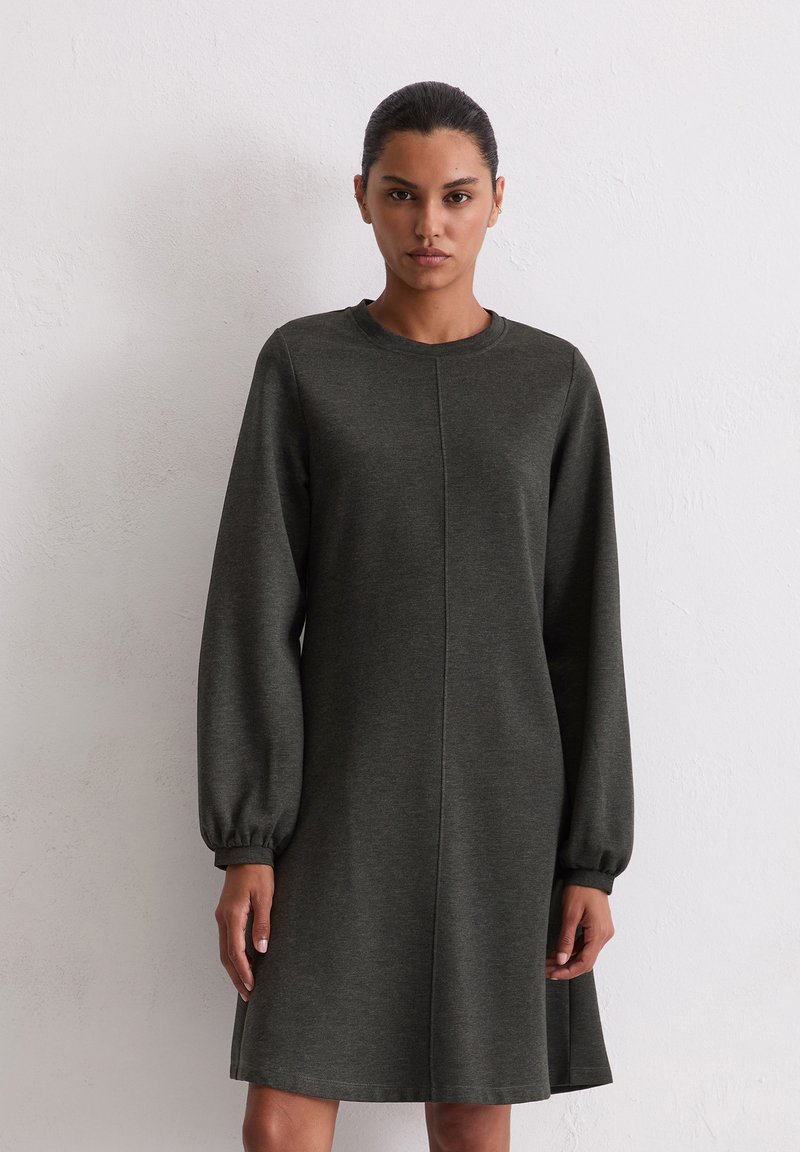 Robe-sweat à manches longues et ballons, de couleur vert foncé et à encolure arrondie. Confectionnée dans un tissu doux et texturé, elle présente une coupe droite simple.