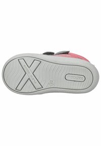 Sko sål med en hvid gummibund med strukturerede riller, en pink stofoverdel med grå detaljer og en velcrorem.