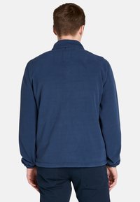Marine fleecejack met een staande kraag, lange mouwen en elastische manchetten. Soepele textuur en minimale naden aan de achterkant.