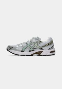 Valge ja hall sportlik jooksujalanõud, mündiroheline ja musta aktsendiga, võrkmaterjalist pealispind ning pehme tallaga valgel taustal.