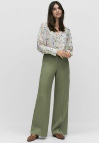 Bloes met bloemenpatroon, lange mouwen en V-hals, gecombineerd met olijfgroene, hoge taille, wijde broek. Zachte stof met een losse pasvorm.