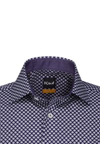 Camicia da dress navy con motivo floreale bianco, vestibilità moderna, colletto classico e chiusura con bottoni. All'interno del colletto presenta un tessuto solido viola.