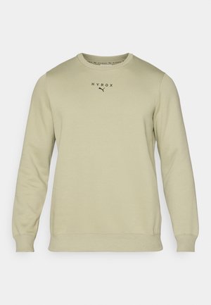 Lichtgroene sweatshirt met lange mouwen, ronde hals en geribde manchetten. Bevat "HYROX" en een Puma-logo in het zwart op de borst. Soepele textuur.