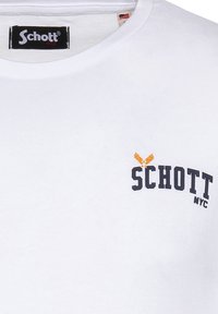 Camiseta de algodón blanca con cuello redondo, logotipo en navy "Schott NYC" con un diseño de águila y mangas cortas. Textura suave.