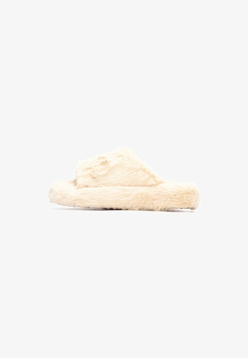 Zapatillas de casa de pelaje en color crema con una textura suave, suela plana y diseño de punta abierta. Presentan una forma redondeada y material de felpa.