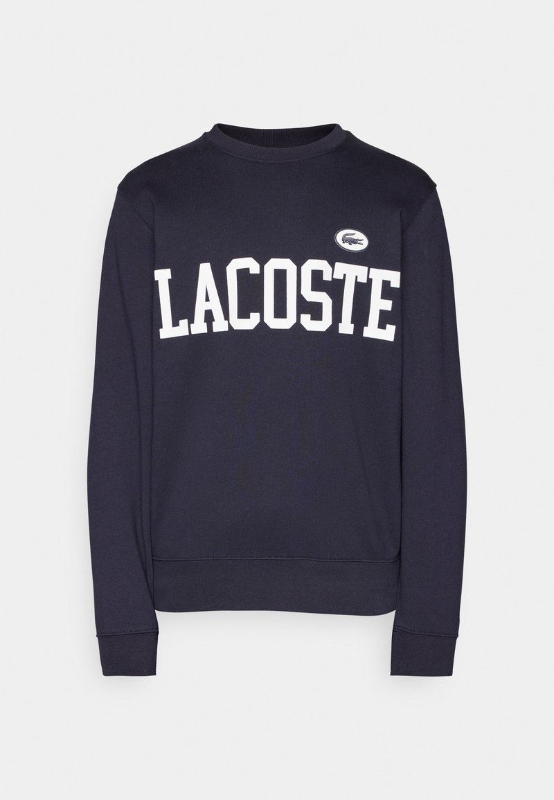 Sudadera de color navy con el texto blanco "LACOSTE" impreso en el pecho y un pequeño logo bordado en el hombro izquierdo. Tejido de mezcla de algodón.