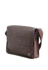 Bolso de hombro de cuero marrón con cierre de solapa, correa ajustable y logo grabado en la parte frontal. Textura suave, forma rectangular.