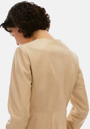 Abito in pelle beige con una texture liscia, scollatura arrotondata e maniche lunghe. Vestibilità su misura con sottili dettagli di cucitura lungo la schiena.
