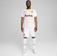 Conjunto de fútbol blanco con rayas verticales amarillas y rojas, logo del patrocinador en negro, escudo del club y pantalones cortos y calcetas a juego.