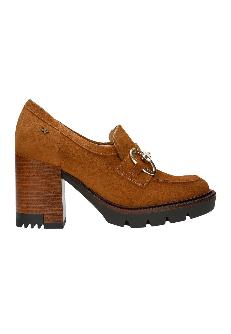 Brown suede heeled loafers with a buckle detail, textured midsole, and chunky black rubber sole. Features a rounded toe and stitched accents.