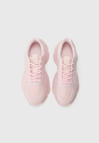 Baskets de sport roses avec une tige en mesh, un col rembourré et une semelle en caoutchouc texturé. Conçues avec un devant à lacets et un design minimaliste.