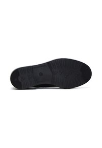 Suela de zapato de goma negra con un patrón de relieve texturado, que presenta ranuras y un logo en el centro, diseñada para mejorar la tracción y la durabilidad.