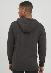 Dark gray hoodie with a drawstring hood, long sleeves, and ribbed cuffs. Soft texture and relaxed fit, designed for comfortable wear.
