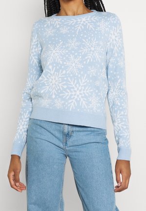 Jersey azul claro con patrón de copos de nieve blancos, combinado con vaqueros azul medio, centrado en el torso y los brazos.