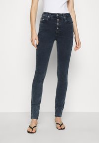 Högmidjade mörkblå skinny jeans i denim, med en femknappsframsida, två framfickor och en figurnära design.