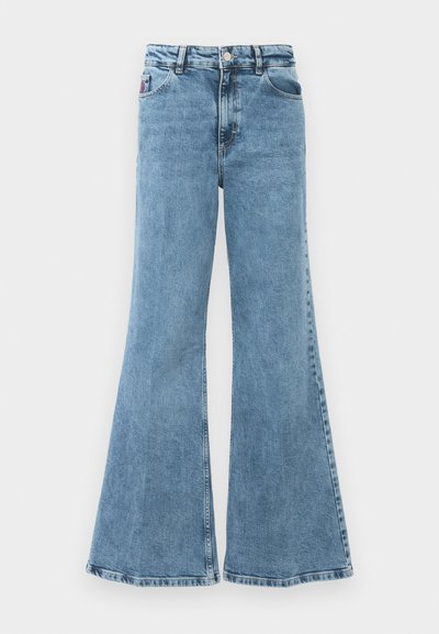 Jeans de mezclilla azul acampanados con cintura alta. Presentan cinco bolsillos, tejido ligero y un lavado desgastado con una textura suave.