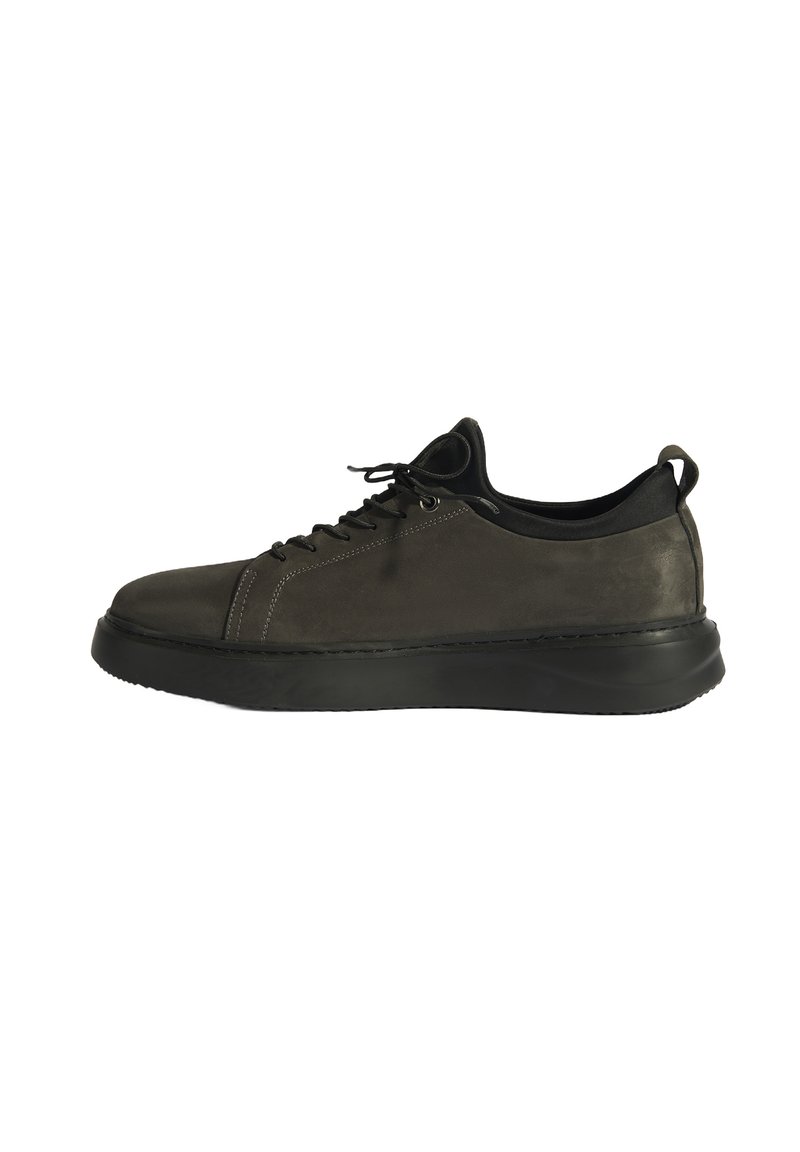 Grijze suède sneakers met een zwarte rubberen zool, ronde neus en platte veters. Voorzien van zijnaadstitching en een trekband aan de achterkant. Minimalistisch design.