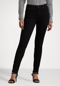 Jeans skinny neri in denim, con un design classico a cinque tasche, bottone in metallo e dettagli di cucitura discreti.