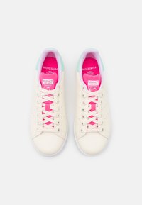Zapatillas de cuero blanco con cordones rosas, una lengüeta trasera verde menta y una plantilla de color rosa brillante con la marca "adidas STAN SMITH."