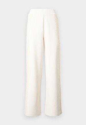 Kreemjad laia lõikega püksid kõrge vöökohaga ja pitsdetailidega pükste väliskülgedel.