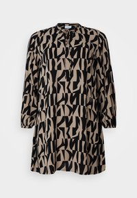 Tunique longue en beige clair avec un motif géométrique abstrait noir, col rond, manches trois-quarts et coupe ample. Le tissu semble texturé.