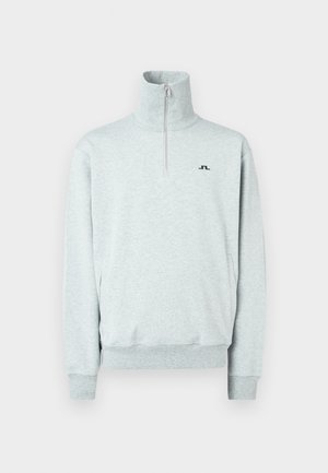 Heled hall kvartsipullover kõrge kaelusega, pikkade varrukatega, soonikkoes mansettide ja alumise servaga, ning vasakul rinnal väike must logo.