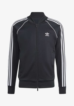 Svart zip-up jacka i mjukt tyg, med tre vita ränder längs varje ärm och en vit Adidas-logotyp på bröstet.