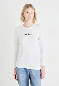Valkoinen pitkähihaine t-paita, jossa on pyöreä kaula-aukko ja musta "Pepe Jeans London" -logo keskitettynä rinnassa. Pehmeä, sileä puuvillamateriaali.