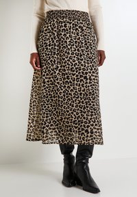 Falda maxi de estampado de leopardo con cintura elástica, hecha de una tela ligera, que presenta una silueta fluida y acentos negros.