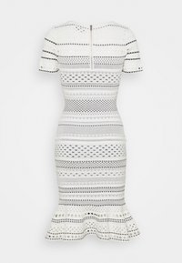 Robe blanche avec des rayures noires à motifs et un ourlet évasé, dotée de manches courtes et d'une fermeture éclair au dos.