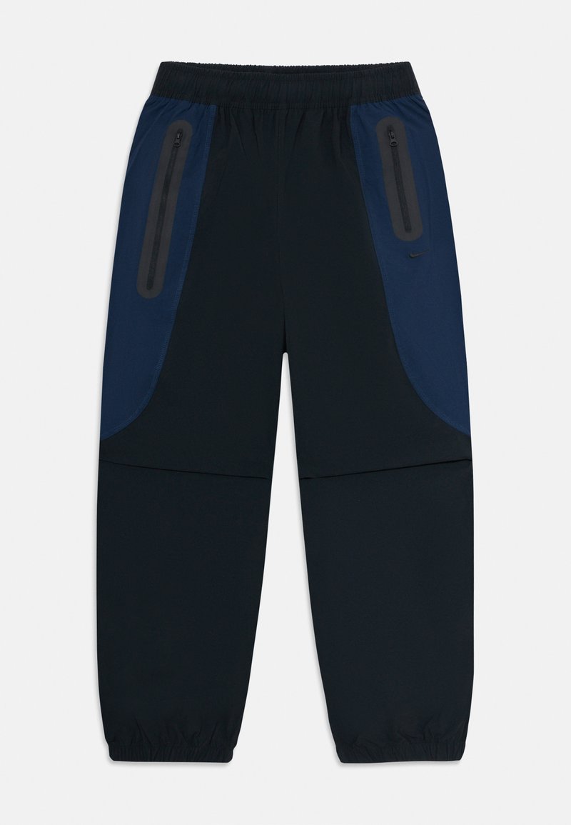 Zwarte en donkerblauwe sportbroek met een elastische tailleband en boorden, en ritszakken aan de zijkant omrand met reflecterende details.