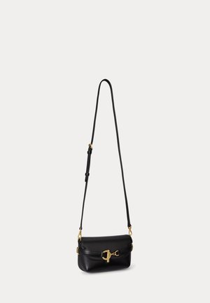 Čierna kožená crossbody taška s nastaviteľným popruhom a detailom zlatého pracka na jednoduchom svetlom pozadí.
