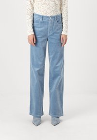 Pantalons en velours côtelé large de couleur bleu clair avec un motif de rayures verticales subtil, comportant des poches avant et une fermeture à bouton à la taille.