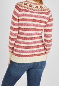 Pull en tricot présentant des rayures horizontales multicolores et en zigzag en rose, rouge et crème. Ourlet et poignets côtelés, encolure ronde.