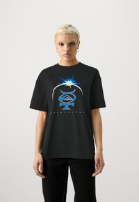 Čierne bavlnené tričko so voľným strihom, s farebným grafickým dizajnom v modrej a bielej farbe a textom "Quiksilver" na spodnej strane.