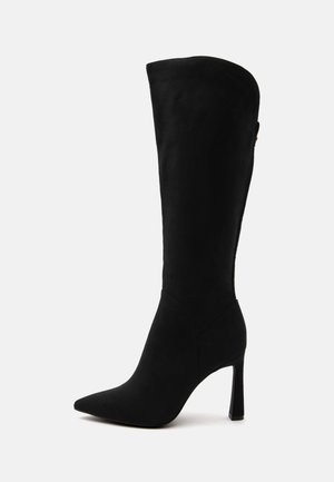 Botte noire pour femme, jusqu'au genou, à bout pointu et talon aiguille haut, présentée de profil sur fond blanc uni.